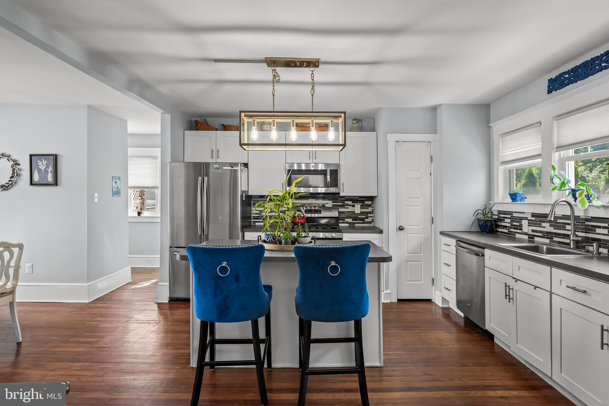 615 North Walnut Avenue Magnolia, NJ 08049 - Photo 10 of 40 a kitchen with stainless steel appliances granite countertop a kitchen island hardwood floor and a sink