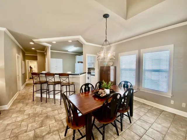 a view of a dining room and livingroom with furniture wooden floor a chandelier