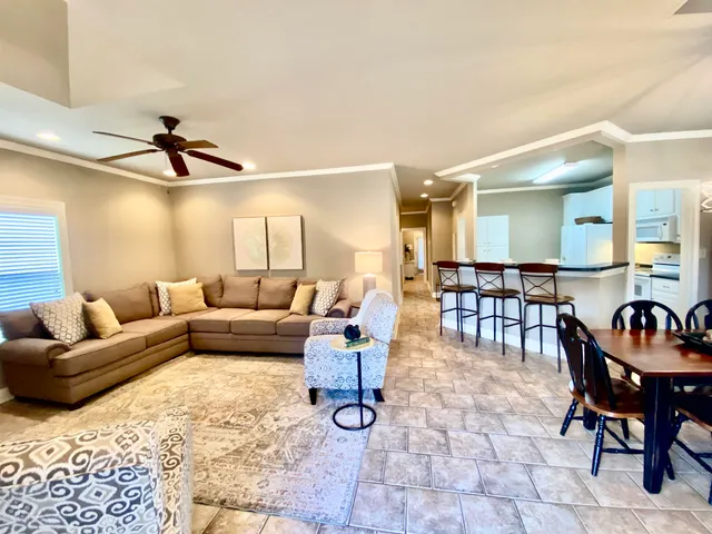 a living room with furniture and a ceiling fan