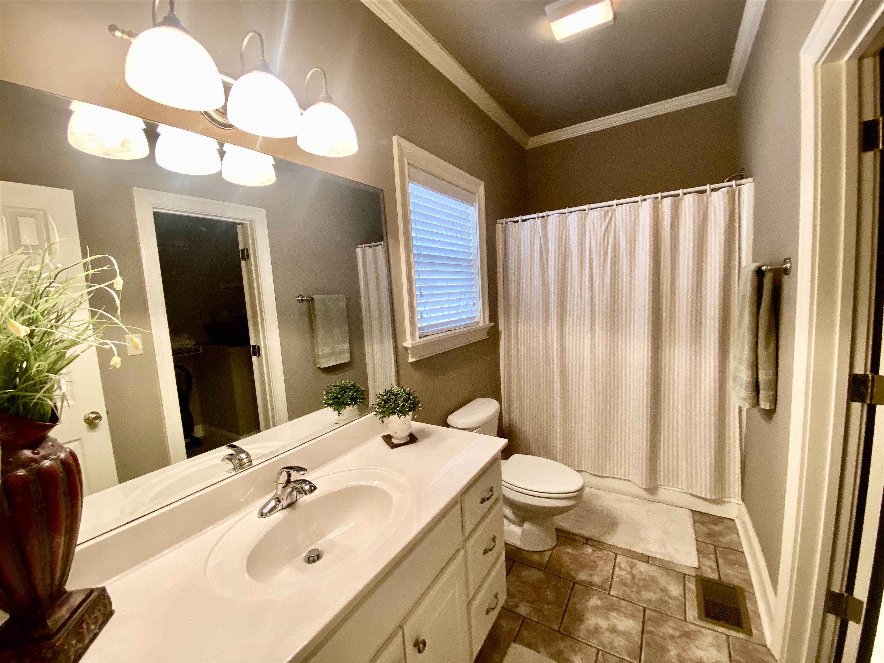 23 Mountain View Iuka, MS 38852 - Photo 21 of 31 a bathroom with a sink a toilet and a large mirror
