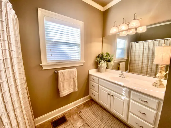 a bathroom with a sink a mirror and a bathtub next to a window