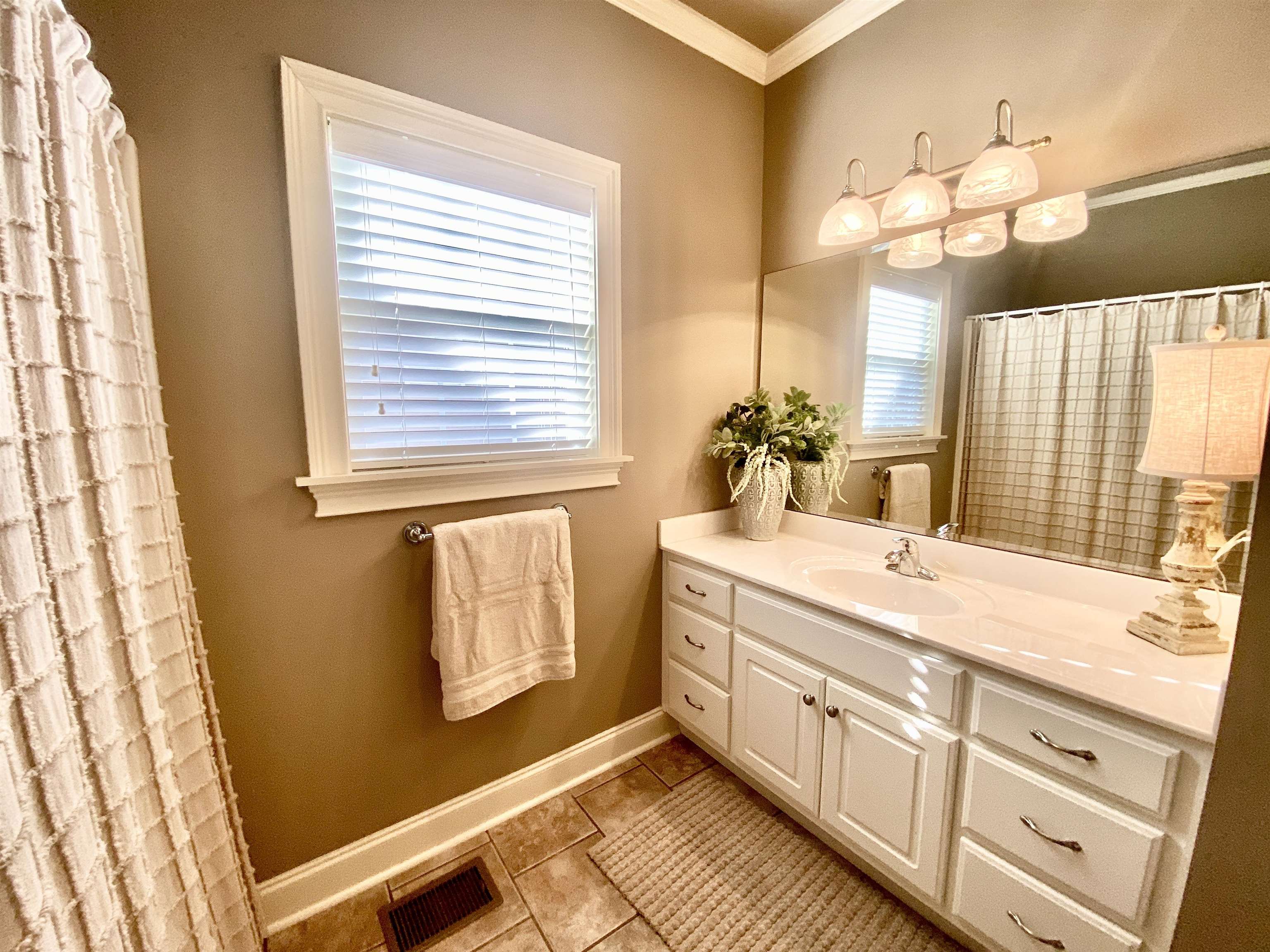 23 Mountain View Iuka, MS 38852 - Photo 23 of 31 a bathroom with a sink a mirror and a bathtub next to a window
