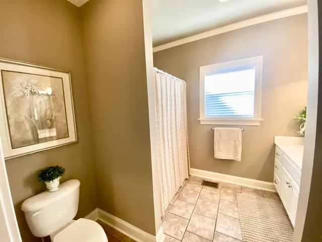 a bathroom with sink toilet window and mirror