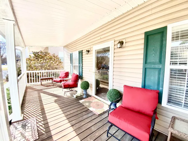 a view of a patio with wooden chairs