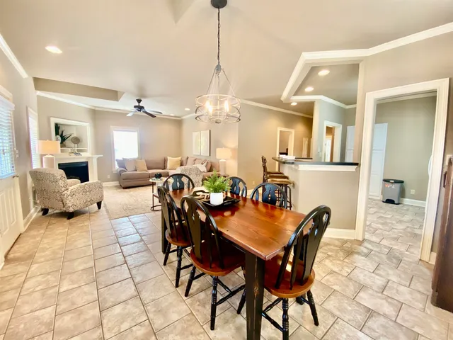 a view of a dining room and livingroom with furniture wooden floor a chandelier
