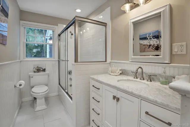 a bathroom with a granite countertop sink toilet and a mirror