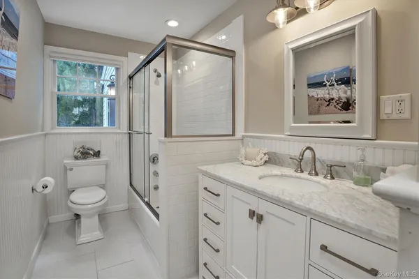 a bathroom with a granite countertop sink toilet and a mirror