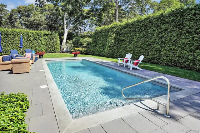 swimming pool view with a seating space