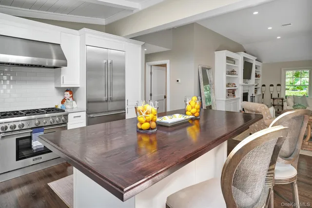 a kitchen with stainless steel appliances granite countertop a stove a sink and a dining table