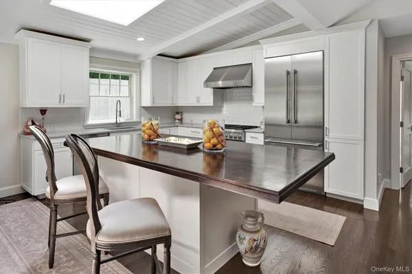 a kitchen with stainless steel appliances granite countertop a sink a stove cabinets counter space and a window