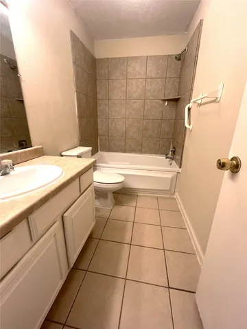 a bathroom with a granite countertop bathtub sink vanity and toilet