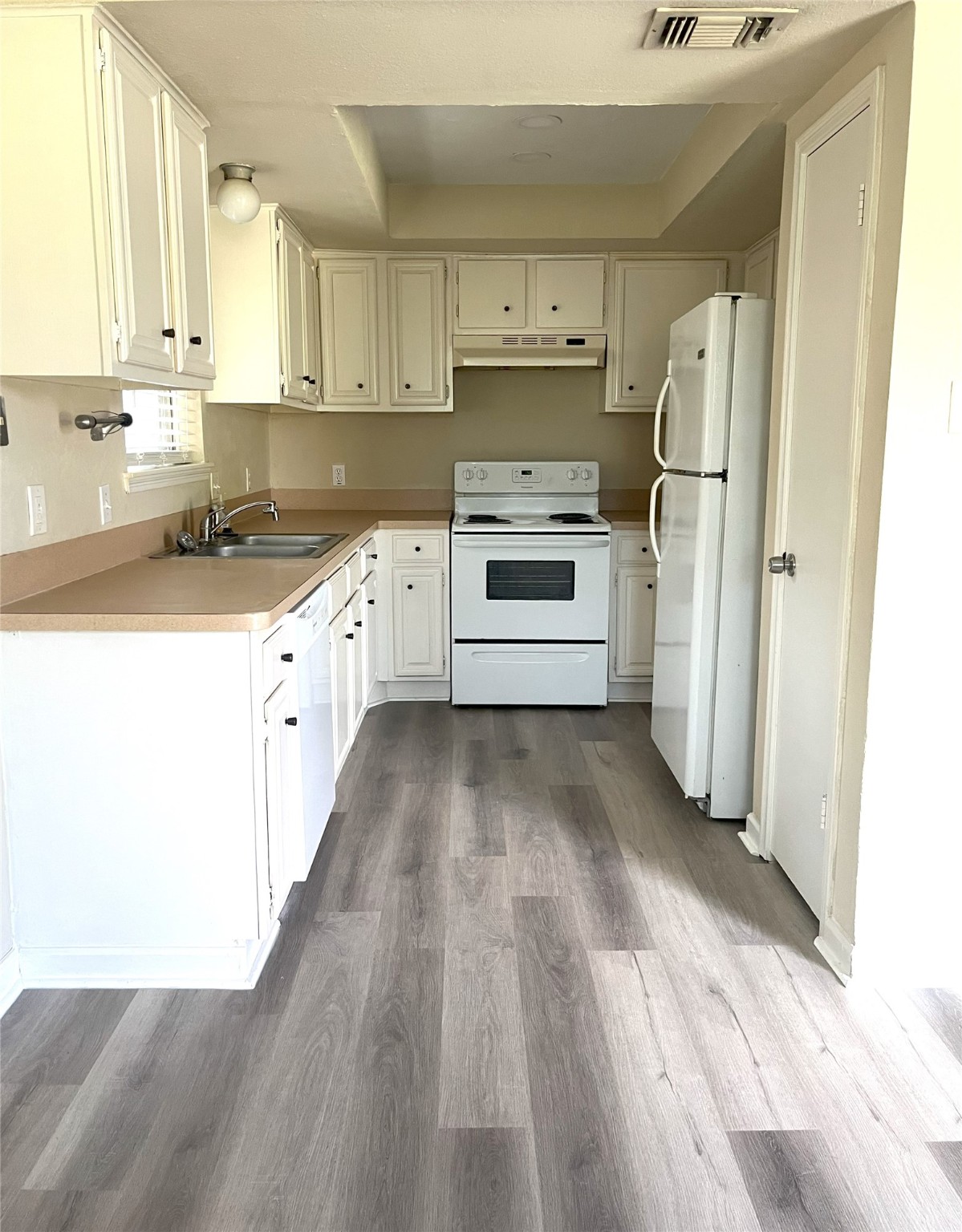 14874 Easingwold Drive Houston, TX 77015 - Photo 4 of 13 a kitchen with a refrigerator a stove top oven and white cabinets