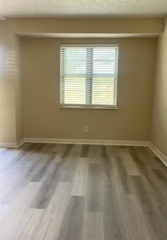 a view of a room with wooden floor and a window