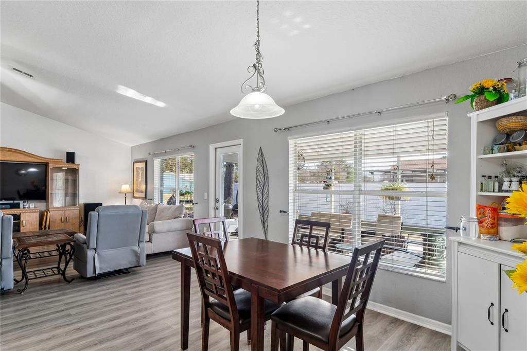 10318 Gifford Drive Spring Hill, FL 34608 - Photo 20 of 57 a dining room with furniture window wooden floor and a chandelier