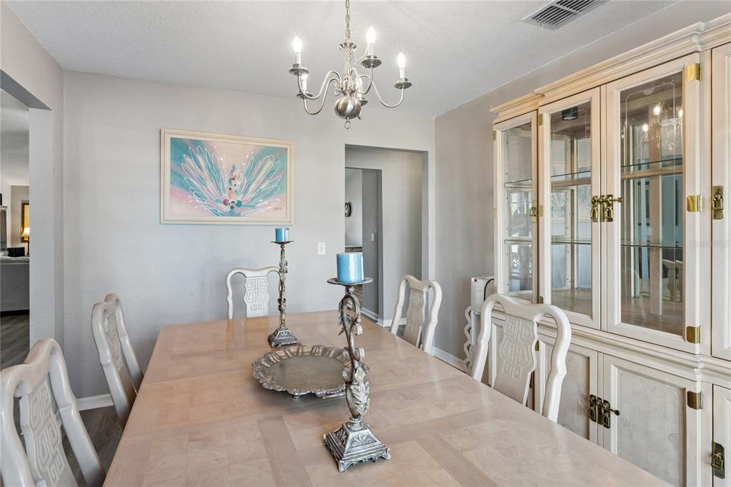 10318 Gifford Drive Spring Hill, FL 34608 - Photo 23 of 57 a living room with furniture a dining table and a chandelier