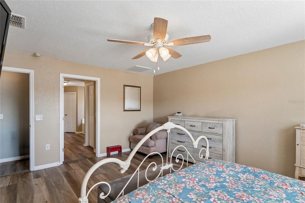 10318 Gifford Drive Spring Hill, FL 34608 - Photo 26 of 57 a bedroom with a bed and a chandelier