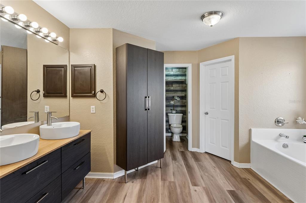 10318 Gifford Drive Spring Hill, FL 34608 - Photo 3 of 57 a spacious bathroom with a double vanity sink a large mirror and shower