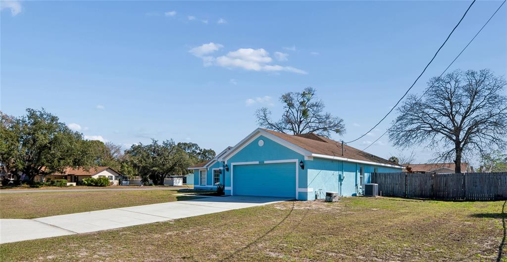 10318 Gifford Drive Spring Hill, FL 34608 - Photo 50 of 57 a view of yellow house with a yard and large trees