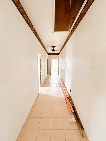 a hallway with a large window and potted plants