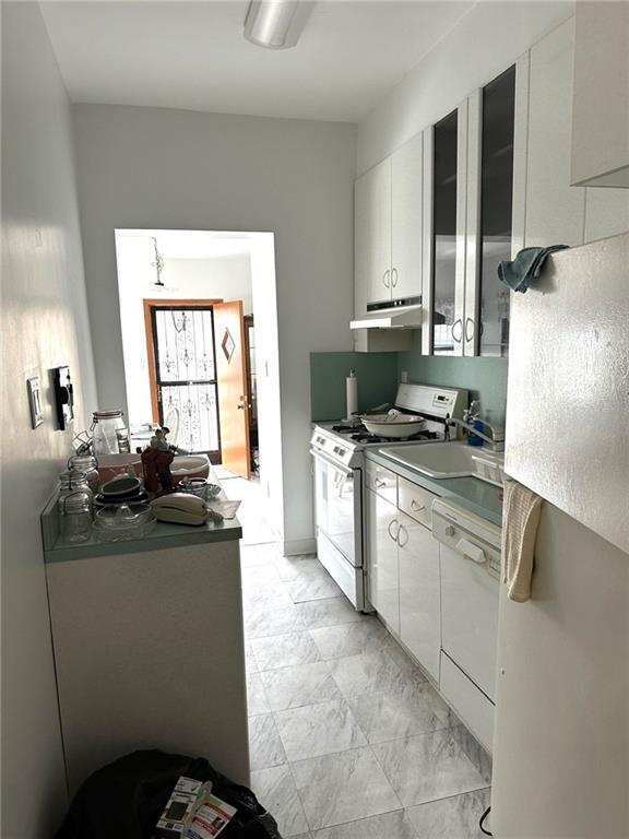 1334 66th Street Brooklyn, NY 11219 - Photo 8 of 15 a kitchen with a stove a sink and a refrigerator