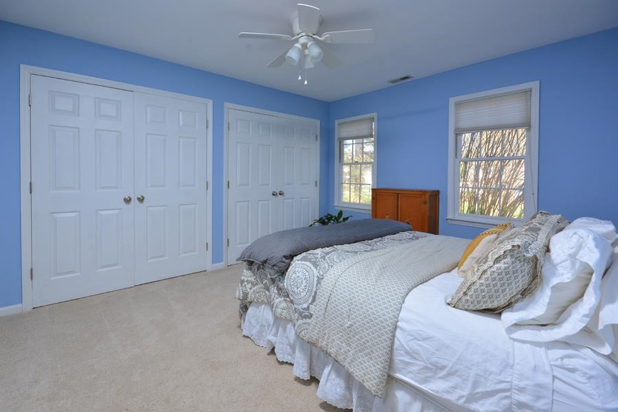 108 Rother Lane Durham, NC 27707 - Photo 23 of 34 a bedroom with a large bed and a chandelier