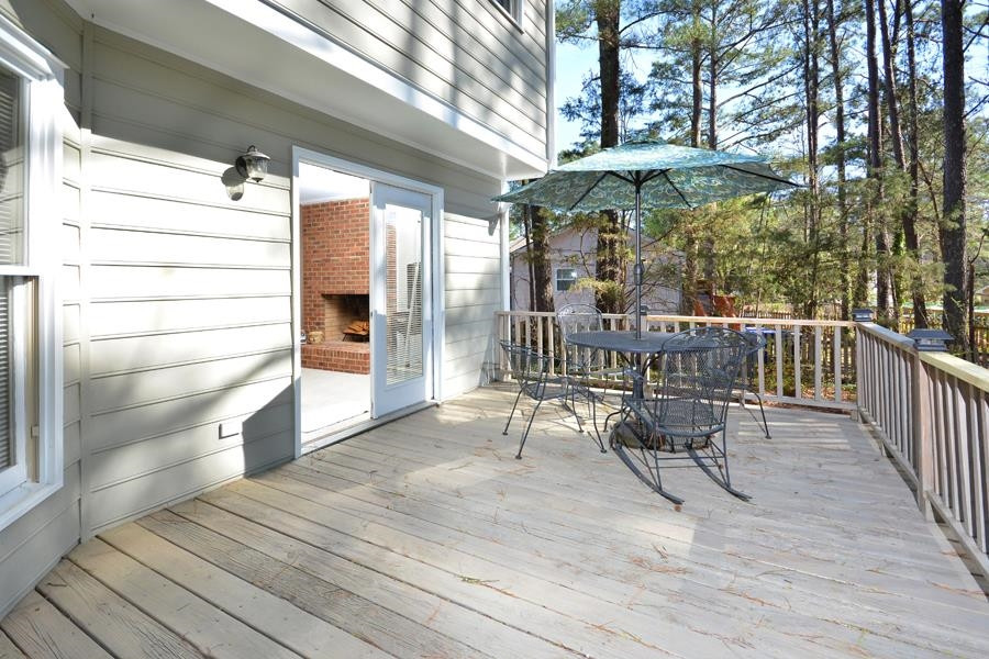 108 Rother Lane Durham, NC 27707 - Photo 31 of 34 a view of a roof deck with table and chairs under an umbrella with wooden floor