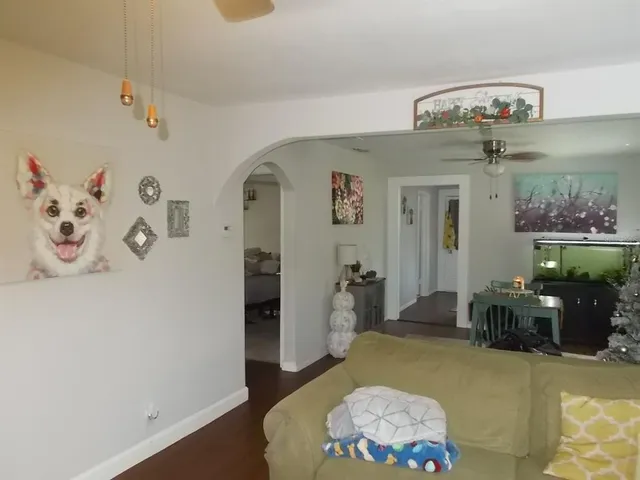 a living room with furniture flowers and wooden floor