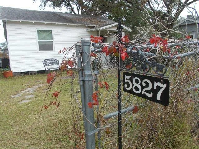 a view of a house with a yard and large tree