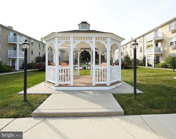 a view of a white house with a yard in front of it