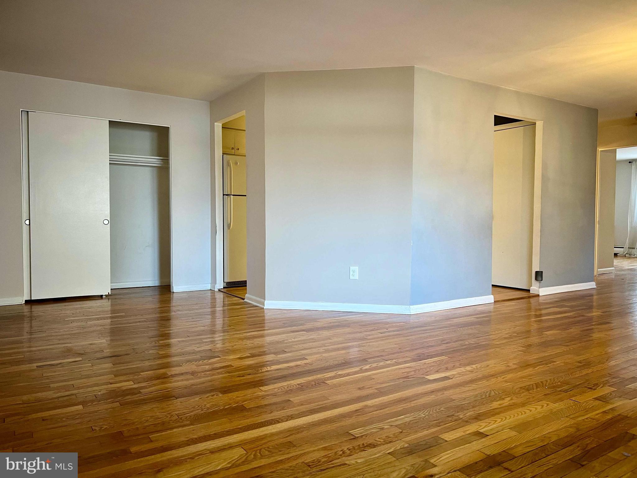 175 West King Street, Unit 107 Malvern, PA 19355 - Photo 5 of 27 a view of an empty room with wooden floor and closet