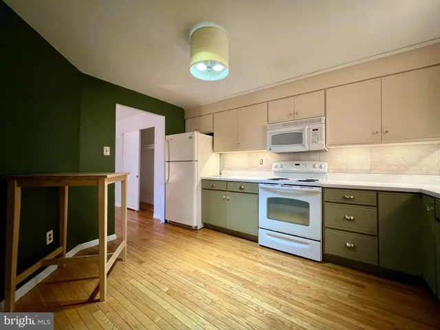 a kitchen with granite countertop a stove a sink and a refrigerator