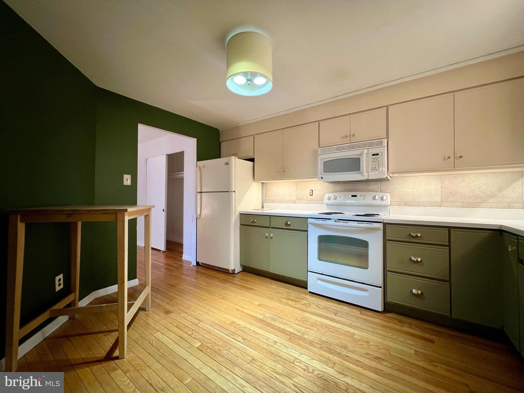 175 West King Street, Unit 107 Malvern, PA 19355 - Photo 7 of 27 a kitchen with granite countertop a stove a sink and a refrigerator