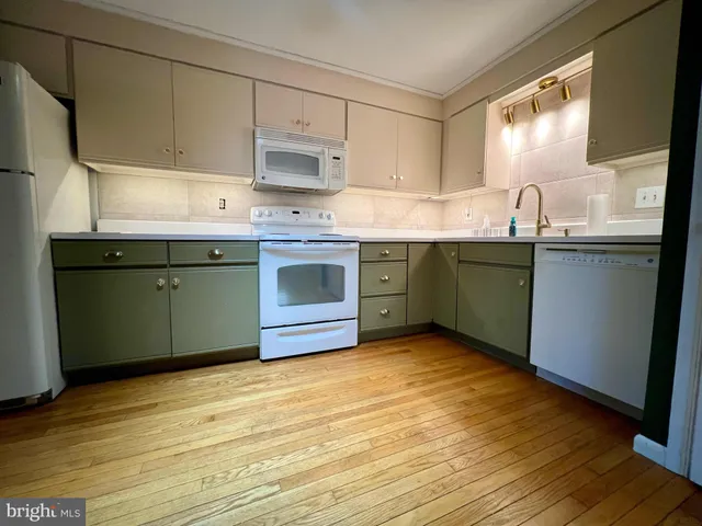 a kitchen with stainless steel appliances granite countertop a sink cabinets and wooden floor