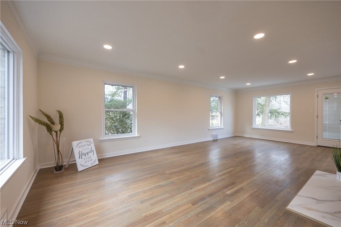 32887 Cedar Road Mayfield Heights, OH 44124 - Photo 6 of 44 Unfurnished room with light hardwood / wood-style flooring, crown molding, and a healthy amount of sunlight
