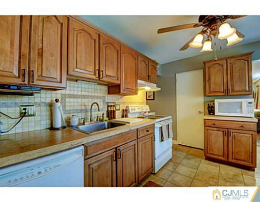 22 Sanders Road Edison, NJ 08817 - Photo 12 of 25 a kitchen with stainless steel appliances granite countertop a sink dishwasher stove and cabinets
