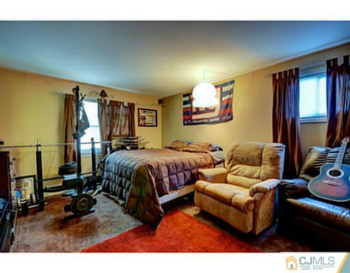 22 Sanders Road Edison, NJ 08817 - Photo 19 of 25 a bedroom with a bed a couch and a flat tv screen on the dresser
