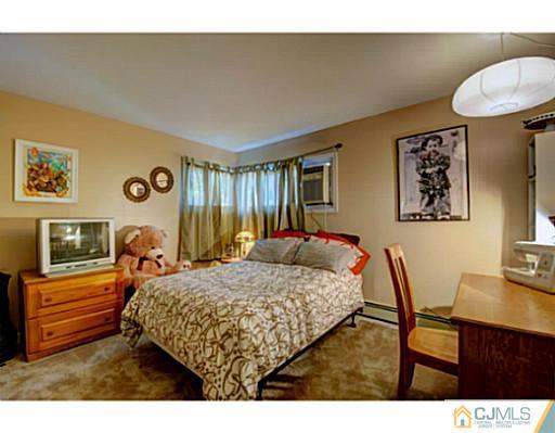 22 Sanders Road Edison, NJ 08817 - Photo 20 of 25 a bedroom with a bed and a table in it