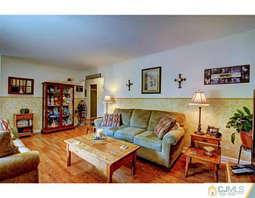 22 Sanders Road Edison, NJ 08817 - Photo 4 of 25 a living room with furniture and a bookshelf