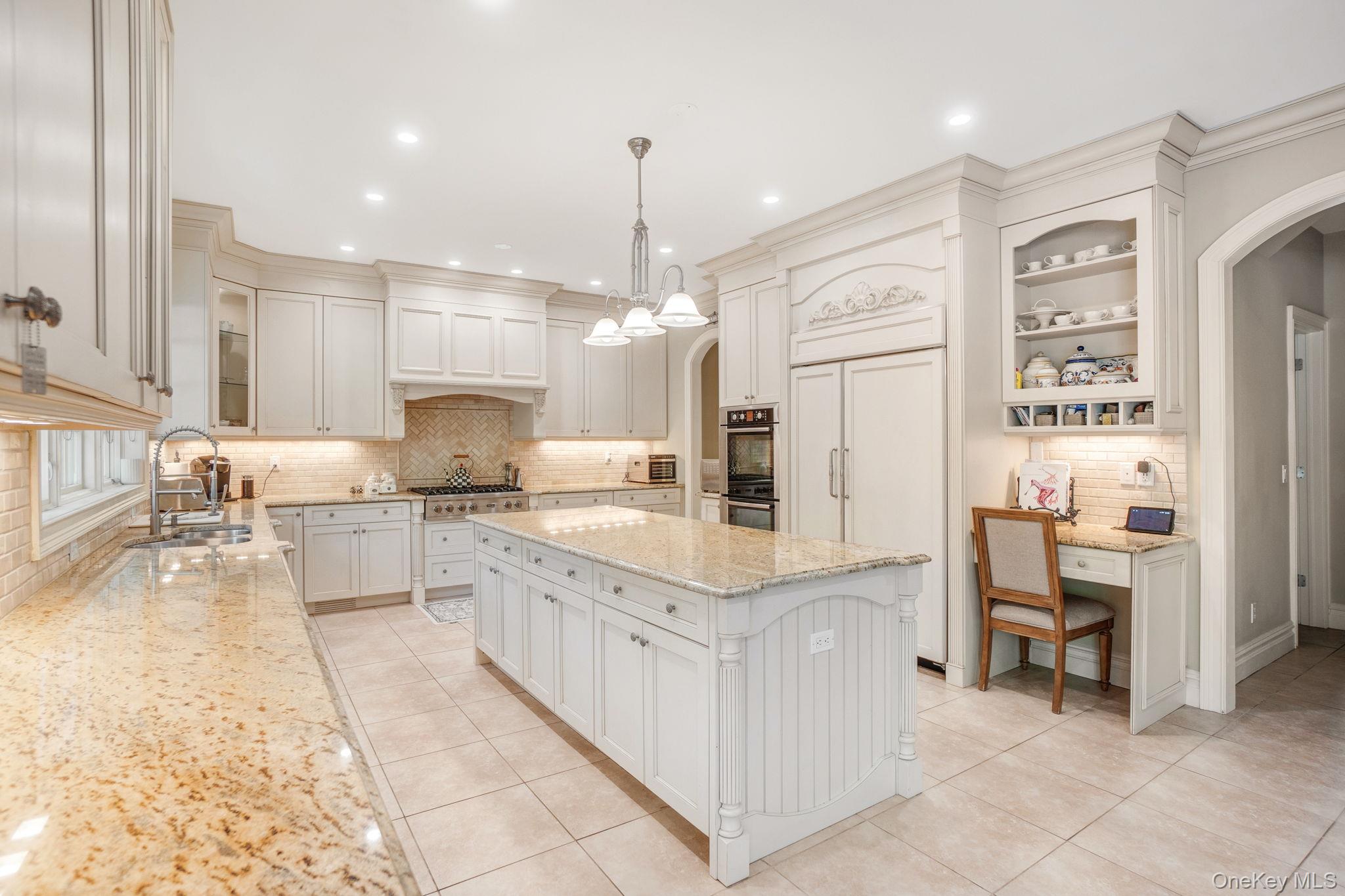 1 Norgate Road Glen Head, NY 11545 - Photo 16 of 42 a large kitchen with kitchen island granite countertop lots of white cabinets a sink dishwasher a dining table and chairs with wooden floor