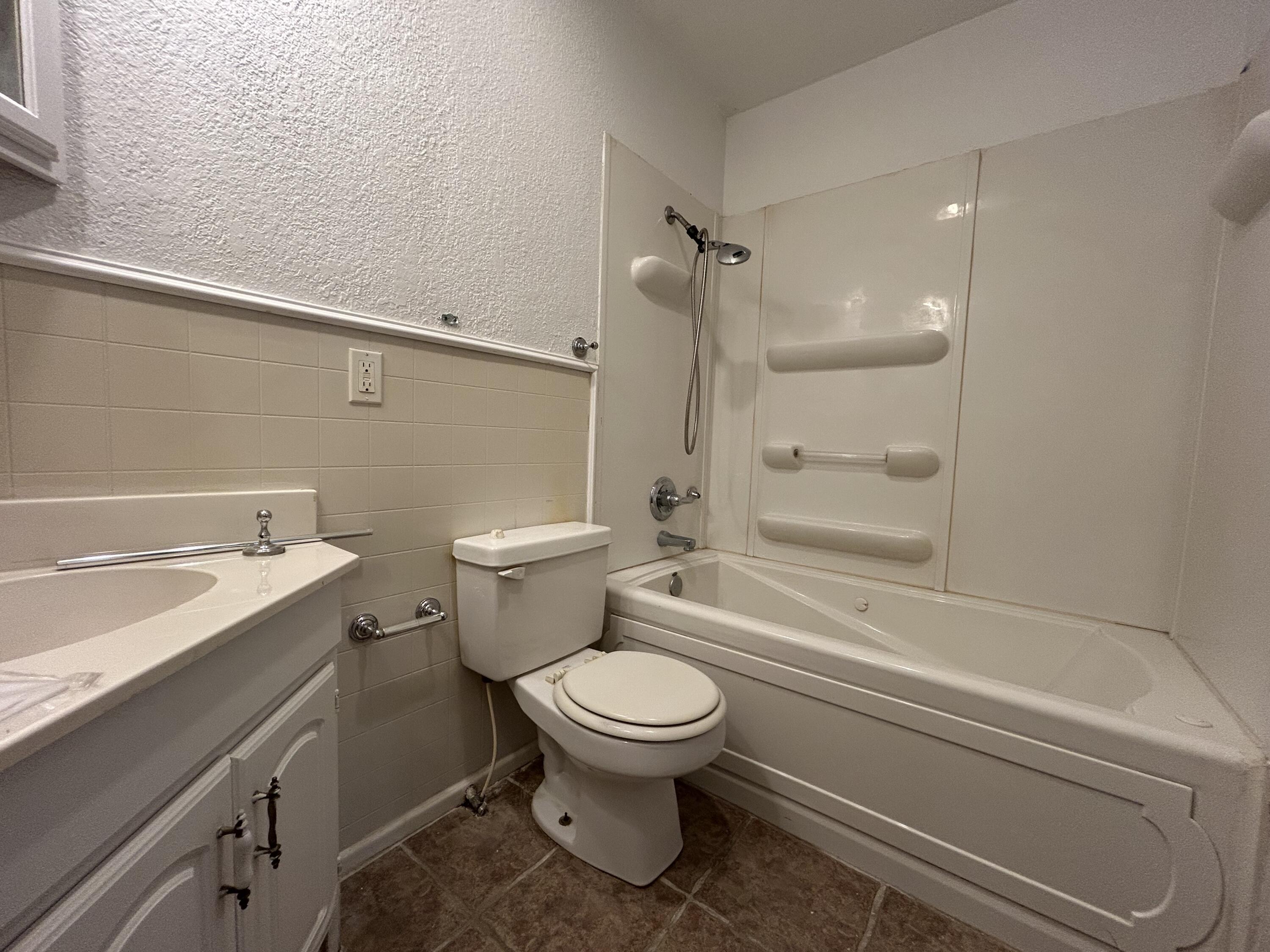 801 North 18th Street Lamesa, TX 79331 - Photo 13 of 15 a bathroom with a granite countertop toilet a sink and bathtub