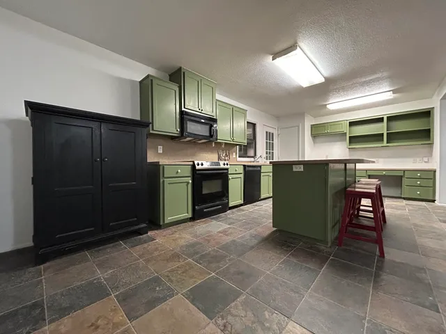 a kitchen with stainless steel appliances granite countertop a stove top oven microwave and cabinets