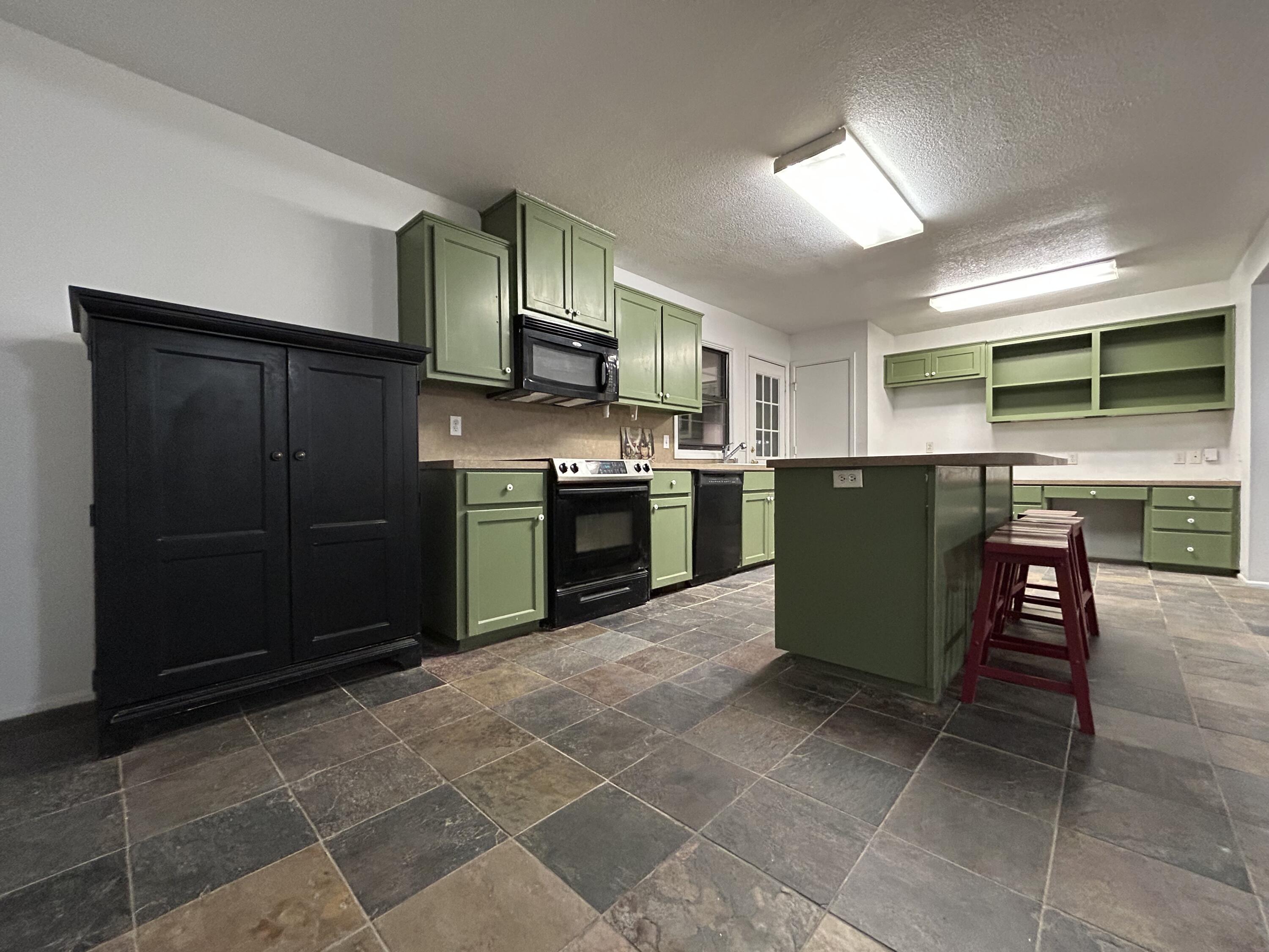 801 North 18th Street Lamesa, TX 79331 - Photo 5 of 15 a kitchen with stainless steel appliances granite countertop a stove top oven microwave and cabinets