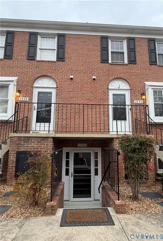 a front view of a house with barbeque grill and potted plants