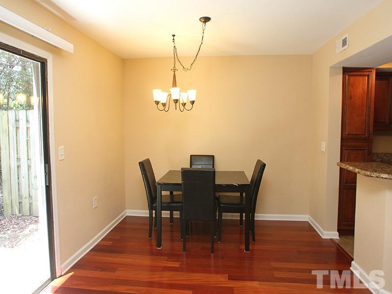 2432 Condor Court, Unit 2432 Raleigh, NC 27615 - Photo 5 of 11 a view of a dining room with furniture wooden floor and a chandelier