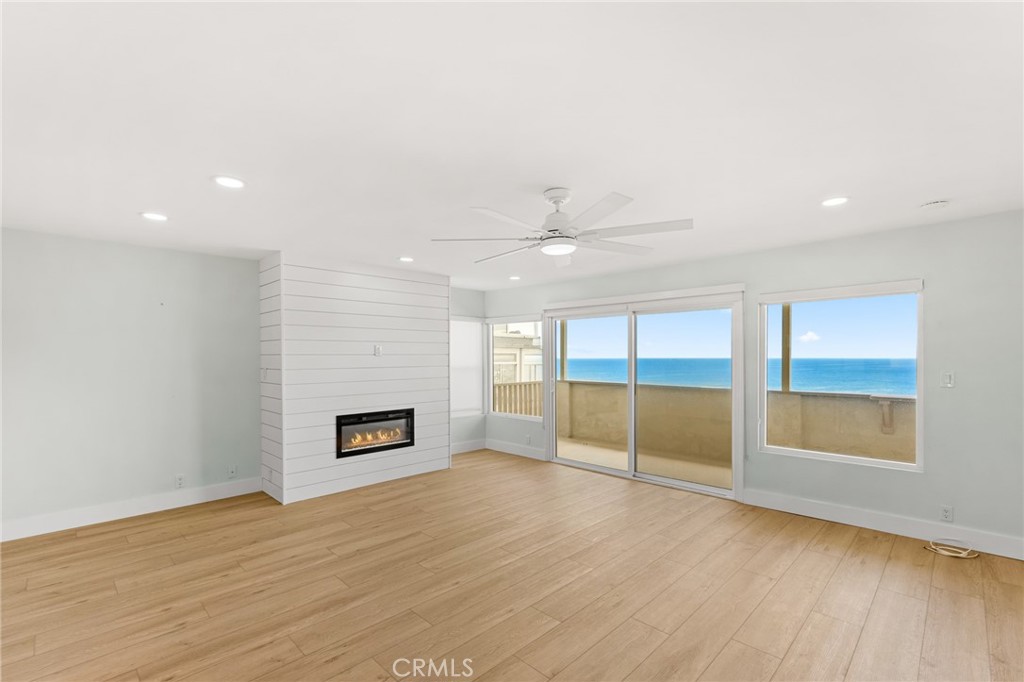 34381 Dana Strand Road, Unit 2 Dana Point, CA 92629 - Photo 7 of 32 an empty room with wooden floor and windows
