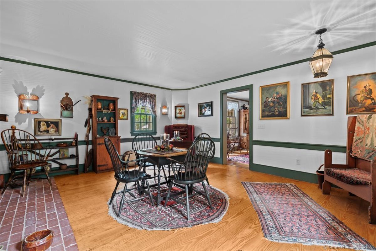 174 Bethel Road Griswold, CT 06351 - Photo 13 of 40 a living room with furniture a dining table and paintings on the wall with wooden floor