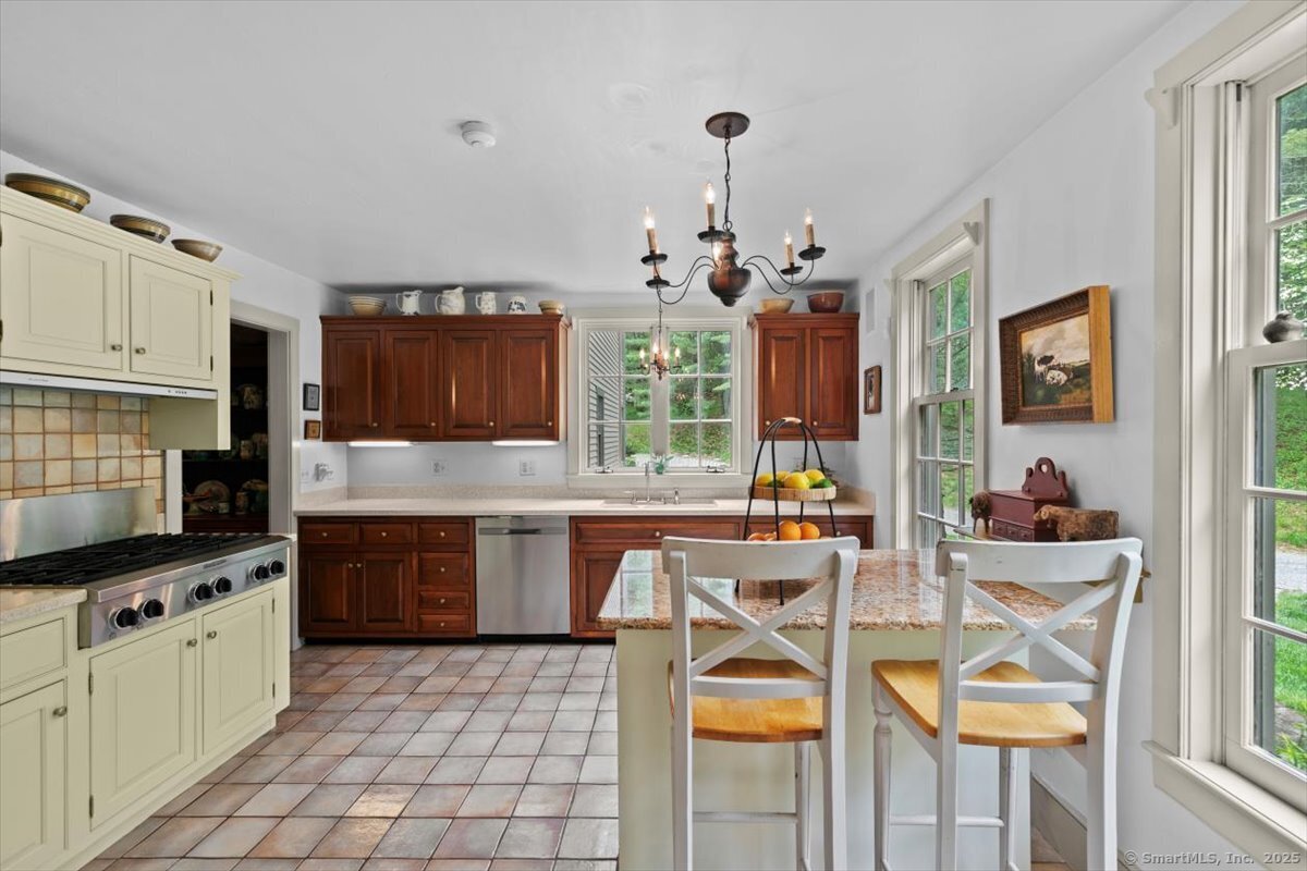 174 Bethel Road Griswold, CT 06351 - Photo 5 of 40 a kitchen with stainless steel appliances granite countertop a stove a sink dishwasher a dining table and chairs with wooden floor