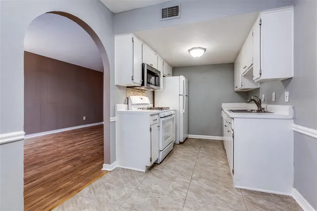 a kitchen with white cabinets and white appliances