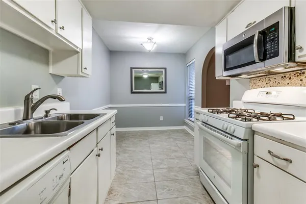 a kitchen with stainless steel appliances a stove a sink and a microwave