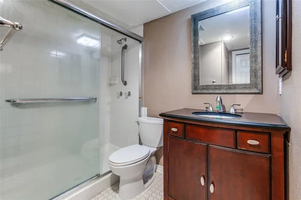 a bathroom with a sink a toilet and shower